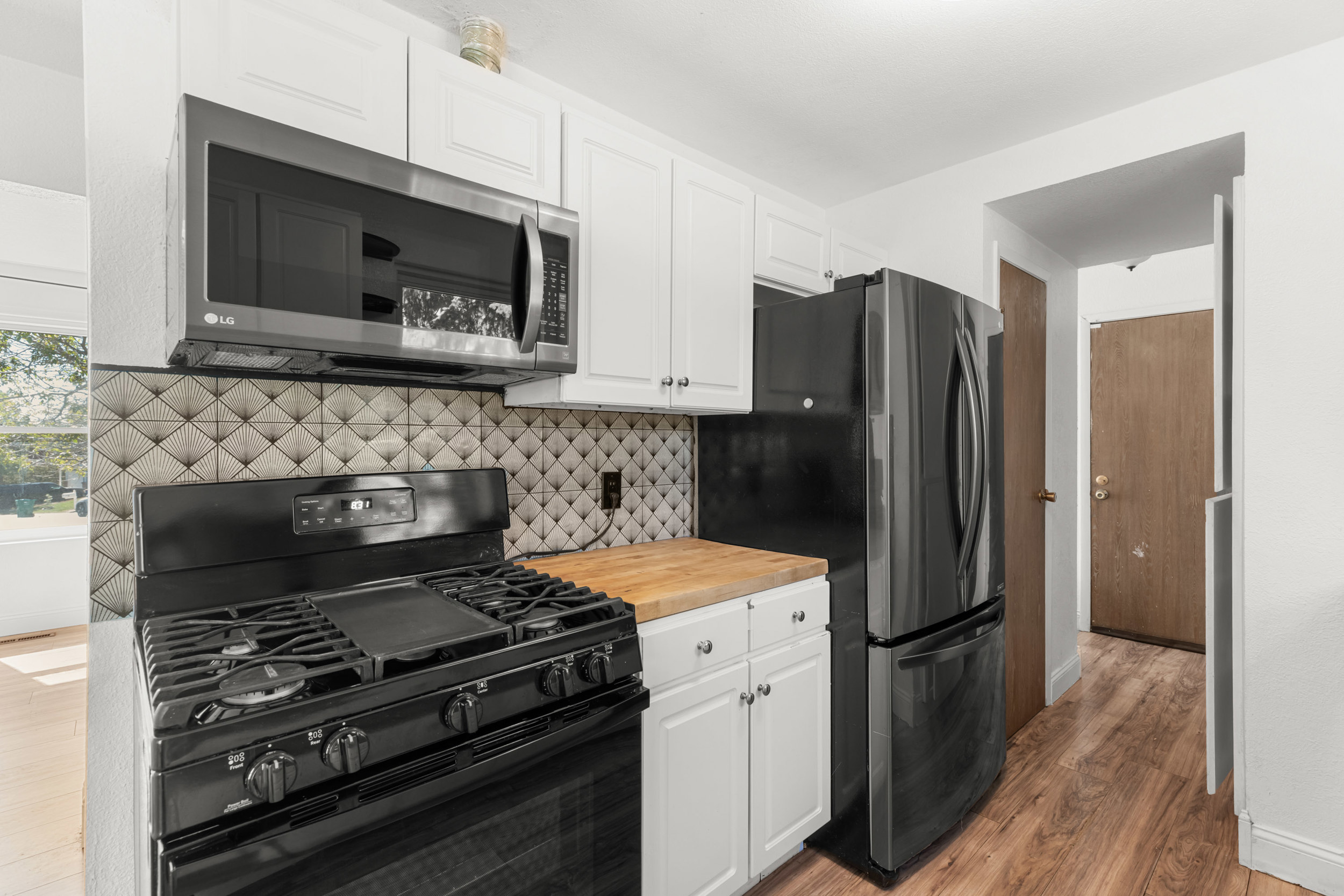 Kitchen with butcher block counters and tile backsplash